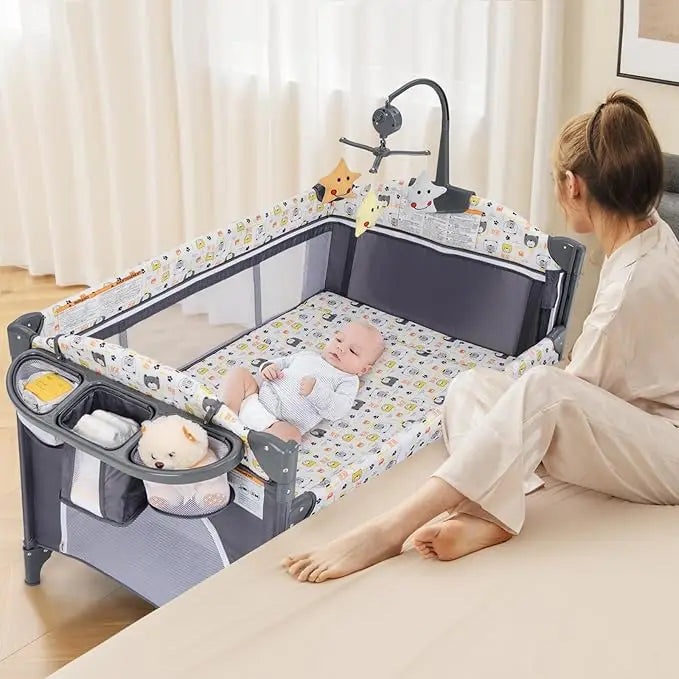 5 in 1 Pack and Play Baby Bedside Sleeper Crib - Portable Baby Crib with Mattress, Bassinet, Diaper Changer, Storage Rack and Music Box Hanging Toy.